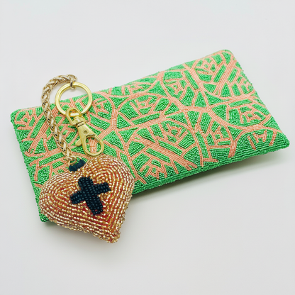 Sacred Heart charm styled with Ivy Rose clutch white background